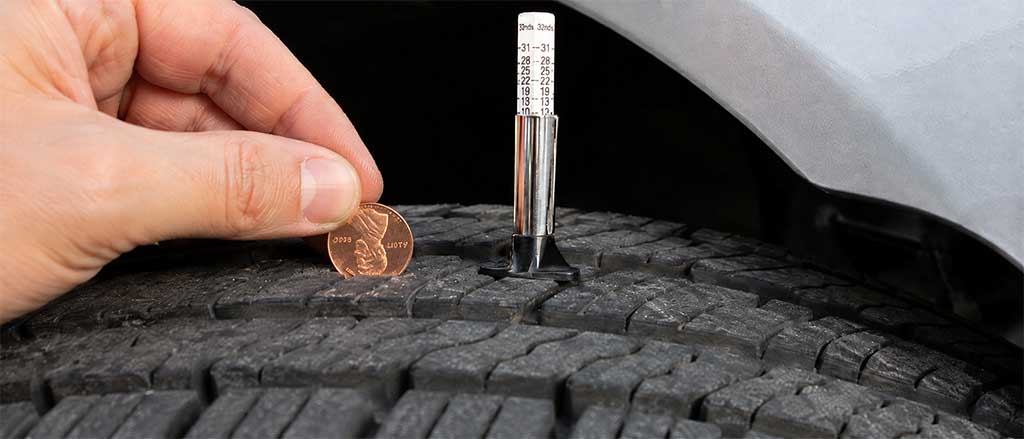 Tread depth gauge next to a penny